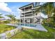 This modern three-story home features a pool, an outdoor lounge, and second and third-story balconies at 820 Bay Point Dr, Madeira Beach, FL 33708
