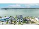Modern waterfront home with a sleek design, complemented by a paved driveway and lush landscaping at 820 Bay Point Dr, Madeira Beach, FL 33708