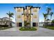 Striking three-story home with modern design, featuring a stone facade, dual garages, and manicured landscaping at 820 Bay Point Dr, Madeira Beach, FL 33708