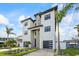 Elegant three-story home with modern architectural details, stone accents, and a well-maintained front garden at 820 Bay Point Dr, Madeira Beach, FL 33708