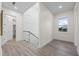 Well-lit hallway with gray wood floors, white walls, and views of the neighborhood at 820 Bay Point Dr, Madeira Beach, FL 33708