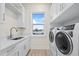 Well-lit laundry room with a large window, modern appliances, and lots of storage at 820 Bay Point Dr, Madeira Beach, FL 33708