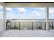 Expansive balcony with white tile flooring and black railings overlooking the water at 820 Bay Point Dr, Madeira Beach, FL 33708