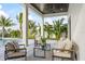 Inviting outdoor patio featuring comfortable seating, ceiling fan, and views of lush tropical landscaping at 820 Bay Point Dr, Madeira Beach, FL 33708