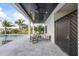 Relaxing patio with seating area next to the pool, features a ceiling fan and stylish gate at 820 Bay Point Dr, Madeira Beach, FL 33708