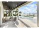 Luxurious covered patio and outdoor living area with a pool overlooking the waterfront view at 820 Bay Point Dr, Madeira Beach, FL 33708