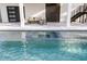 Beautiful pool with spa features a patio area and access to the home's modern outdoor staircase at 820 Bay Point Dr, Madeira Beach, FL 33708