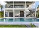 The bright, clear pool offers an outdoor seating area and access to balconies on this multi-story home at 820 Bay Point Dr, Madeira Beach, FL 33708