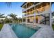 Luxury home with a modern pool, outdoor seating, and balconies, perfect for entertaining at 820 Bay Point Dr, Madeira Beach, FL 33708