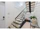 Modern staircase with glass railing, light wood steps, and stylish accents creates an open design at 820 Bay Point Dr, Madeira Beach, FL 33708