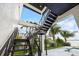Modern outdoor stairway with metal railings leading up, surrounded by tropical landscaping at 820 Bay Point Dr, Madeira Beach, FL 33708