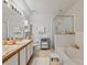 Spacious bathroom with dual sinks, soaking tub, and a tiled glass shower, providing a luxurious and relaxing experience at 9616 Carlsdale Dr, Riverview, FL 33578