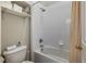 Bright bathroom featuring a shower-tub combo with white tiles and a functional toilet with storage at 9616 Carlsdale Dr, Riverview, FL 33578