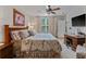 Inviting bedroom featuring large windows, a ceiling fan, and a desk, offering ample natural light and comfort at 9616 Carlsdale Dr, Riverview, FL 33578