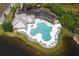 An aerial view of a clover-shaped pool with lounge chairs and an adjacent playground at 9616 Carlsdale Dr, Riverview, FL 33578