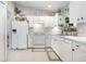 Bright kitchen features white cabinetry, countertops, and appliances plus plants near the window at 2816 Soprano Ln, North Port, FL 34286