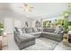 Open-concept living room featuring a sectional sofa, large windows, and neutral color scheme at 2816 Soprano Ln, North Port, FL 34286