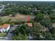 An aerial shot showcases a home with a tile roof amidst lush greenery and adjacent residences at 3118 W Bay Villa Ave, Tampa, FL 33611