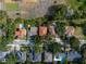 Aerial view of a property with a tile roof surrounded by lush greenery and neighboring homes at 3118 W Bay Villa Ave, Tampa, FL 33611