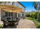 Outdoor patio featuring wicker furniture, a table, an umbrella, a screened-in porch, and lush landscaping at 3118 W Bay Villa Ave, Tampa, FL 33611