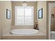 Elegant bathroom featuring a large soaking tub, tile surround, and chandelier at 3118 W Bay Villa Ave, Tampa, FL 33611