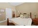 Well-lit bedroom boasts warm carpet, a wood bedframe, and access to an ensuite bathroom at 3118 W Bay Villa Ave, Tampa, FL 33611