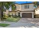 Beautiful two-story home featuring a manicured lawn, tile roof, a paved driveway, and an attached two-car garage at 3118 W Bay Villa Ave, Tampa, FL 33611