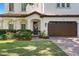 Close up of a meticulously landscaped front yard, a two-car garage, and a covered entryway at 3118 W Bay Villa Ave, Tampa, FL 33611