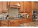 Gourmet kitchen featuring custom cabinets, granite countertops, stainless steel appliances, and a decorative tile backsplash at 3118 W Bay Villa Ave, Tampa, FL 33611
