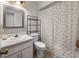 Bathroom with a sink, toilet, decorated shower curtain, and a tiled backsplash on the mirror at 1009 Sagamore Dr, Seffner, FL 33584