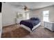 Cozy bedroom featuring a ceiling fan, two bright windows and a large bed with a black comforter at 1009 Sagamore Dr, Seffner, FL 33584
