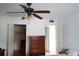 Bright bedroom featuring a ceiling fan, dresser, and ample closet space, perfect for organization and comfort at 101 Cambridge Trl # 205, Sun City Center, FL 33573