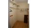 Organized walk-in closet featuring wood floors, shelving, and hanging racks for optimal storage solutions at 101 Cambridge Trl # 205, Sun City Center, FL 33573