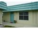 Charming condo with turquoise accents, including door and trim, creating a vibrant and welcoming entrance at 101 Cambridge Trl # 205, Sun City Center, FL 33573