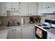 Functional kitchen with white cabinets, tile countertops, modern appliances, and efficient layout for cooking at 101 Cambridge Trl # 205, Sun City Center, FL 33573