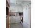 Efficient kitchen featuring white cabinets, tile countertops, and modern appliances, optimizing space and functionality at 101 Cambridge Trl # 205, Sun City Center, FL 33573