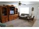 Comfortable living room featuring a neutral sofa, entertainment center, and natural light filtering through a window at 101 Cambridge Trl # 205, Sun City Center, FL 33573