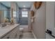 This renovated bathroom features blue subway tile in the shower/tub and a white vanity with a grey countertop at 102 7Th Se Ave, Largo, FL 33771