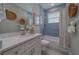 This renovated bathroom features blue subway tile in the shower/tub and a white vanity with a grey countertop at 102 7Th Se Ave, Largo, FL 33771