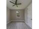 This bedroom features wood-look flooring, modern ceiling fan, neutral paint and a double door closet at 102 7Th Se Ave, Largo, FL 33771