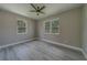 This bedroom features wood-look flooring, modern ceiling fan, neutral paint and plenty of natural light from the double windows at 102 7Th Se Ave, Largo, FL 33771
