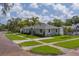 Charming single-story home featuring lush green lawn, lovely curb appeal, mature trees, and manicured landscape at 102 7Th Se Ave, Largo, FL 33771
