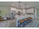 Bright kitchen features white cabinets, stainless steel appliances, island with barstool seating, and pendant lighting at 102 7Th Se Ave, Largo, FL 33771