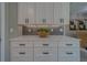 Kitchen detail featuring white cabinetry, quartz countertop, mosaic tile backsplash, and modern decor at 102 7Th Se Ave, Largo, FL 33771