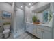 Modern main bathroom with double vanity sinks, white cabinets, and a glass-enclosed shower at 102 7Th Se Ave, Largo, FL 33771