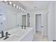 Well-lit bathroom with double sinks, quartz countertop vanity, and separate shower and toilet areas at 10414 Hallmark Blvd, Riverview, FL 33578
