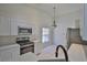 Bright kitchen featuring stainless steel appliances, white cabinets, quartz countertops, and tile floors at 10414 Hallmark Blvd, Riverview, FL 33578