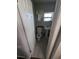 Bathroom featuring tiled walls, pedestal sink, toilet, window, mirror, and white door at 1107 Grant St, Clearwater, FL 33755