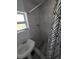 Bathroom featuring tiled walls, pedestal sink, toilet, window, and shower with curtain at 1107 Grant St, Clearwater, FL 33755