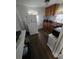 Compact kitchen with wood cabinets, white appliances, and dark flooring at 1107 Grant St, Clearwater, FL 33755